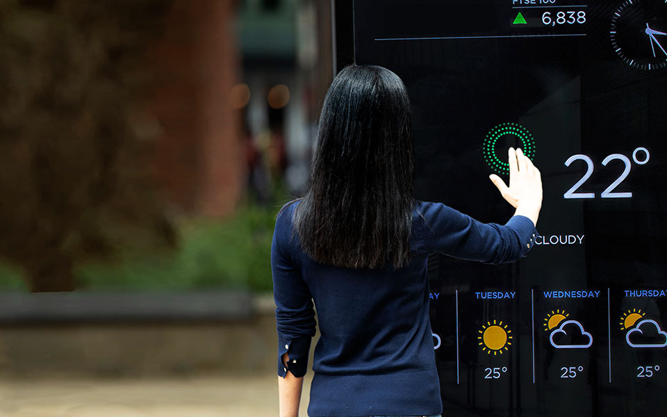 Woman interacting with a hygiene touchless interactive kiosk